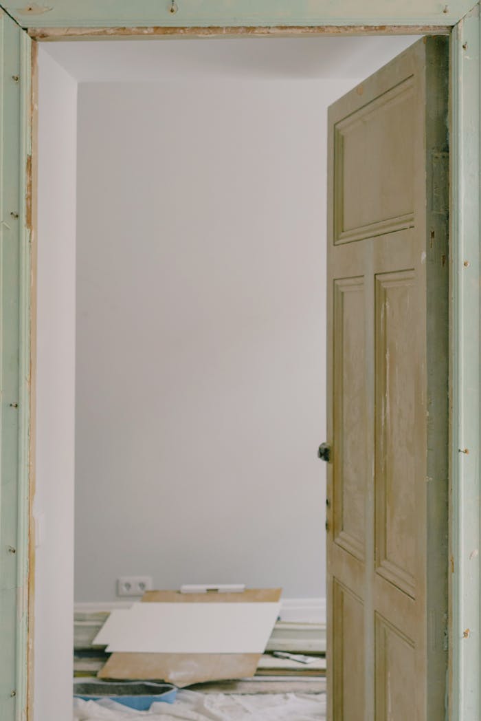 Wooden door in room with pile of construction materials at home during renovation process